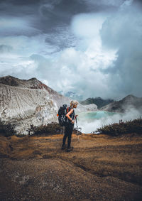 Man standing on mountain road against sky