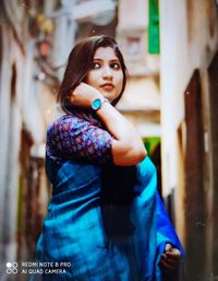 Beautiful young woman standing against wall