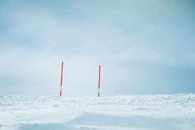 Red umbrella on snowcapped field against sky