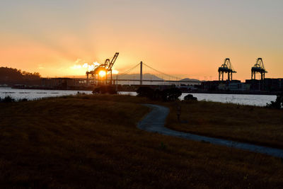 Bridge over river against sky during sunset