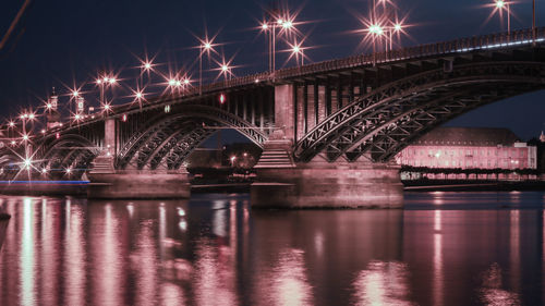 Illuminated bridge over river at night