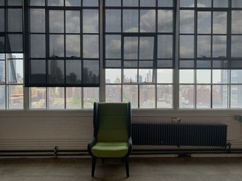 Empty chairs against glass windows facade and blinds 