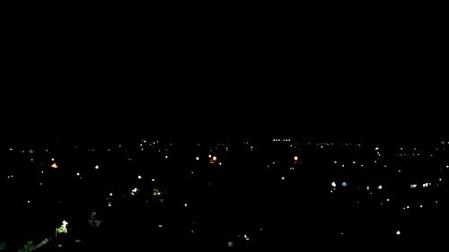 Illuminated cityscape against sky at night