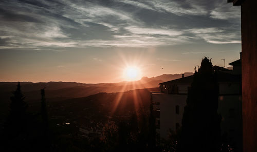 Silhouette buildings against sky during sunset