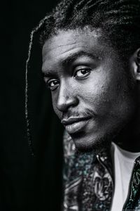 Portrait of young man against black background