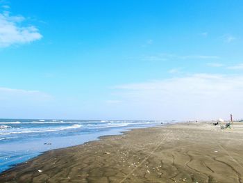 Scenic view of beach against blue sky