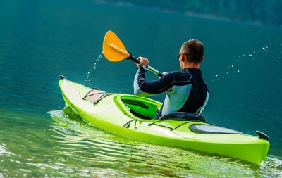 Rear view of boy enjoying in boat