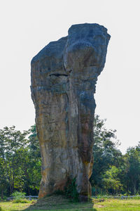 View of rock formation on field against clear sky