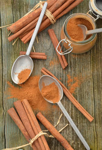 Cinnamon powder spice, cinnamon sticks, spice jar, pewter spoons,