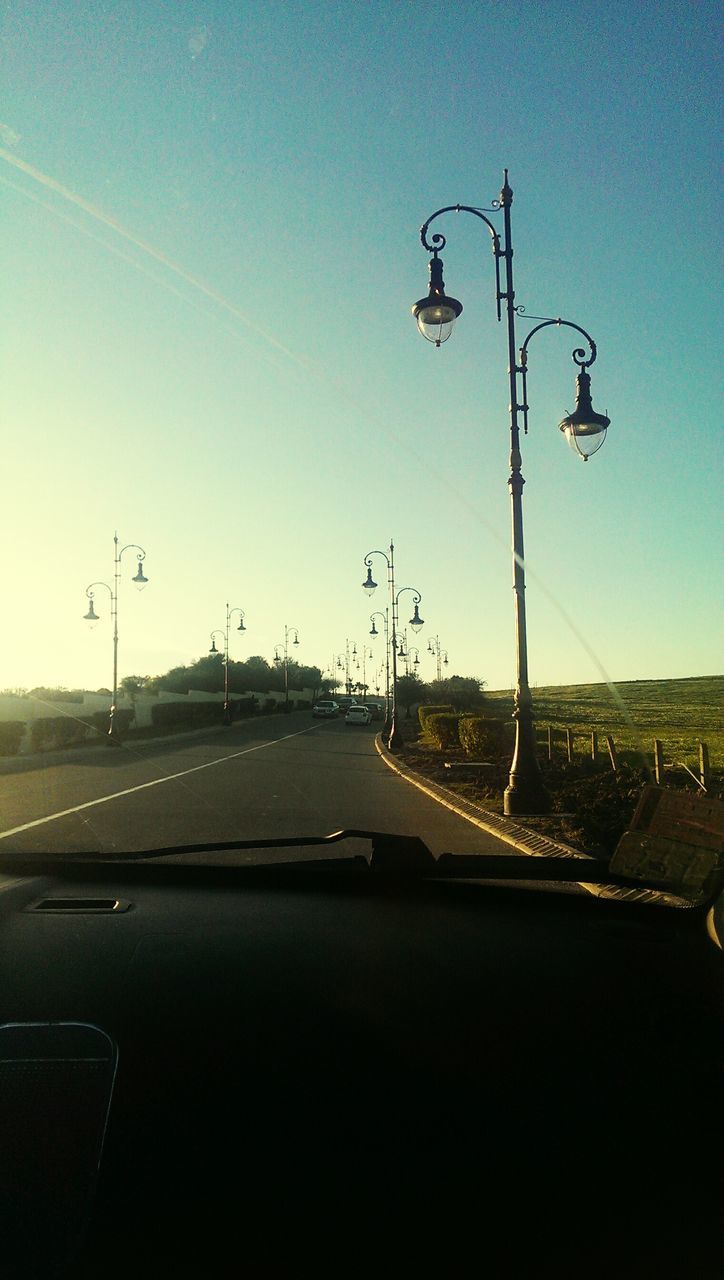 transportation, mode of transport, road, car, clear sky, land vehicle, road marking, windshield, on the move, the way forward, vehicle interior, travel, street light, copy space, transparent, diminishing perspective, sky, journey, blue, car point of view