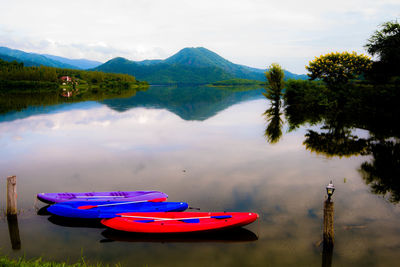 Boats moored in lake against sky