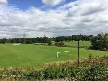 Scenic view of grassy field against cloudy sky