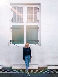 Portrait of woman standing against building