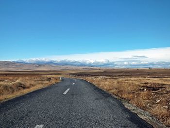 Empty road on landscape against sky