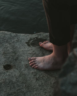 Low section of woman standing by sea