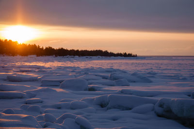 Scenic view of frozen sea against sky during sunset