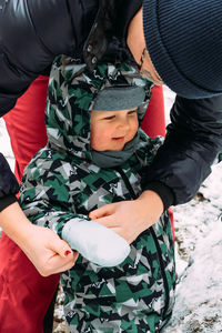 Midsection of mother holding son while standing in winter
