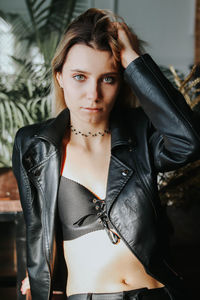 Portrait of beautiful young woman wearing black jacket at home