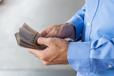 Midsection of businessman counting money