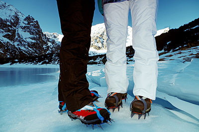 Low section of people standing on frozen lake during winter