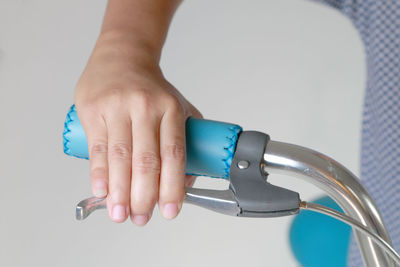 Close-up of person holding hands against blue background