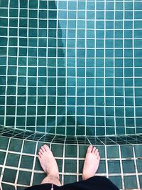 Low section of man relaxing on swimming pool