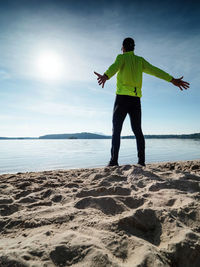 Morning workout. warming up before training. sportsman in sportswear stretching on beach at sunrise