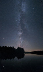 Scenic view of lake against sky at night with milky way