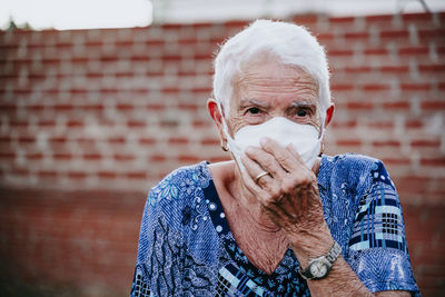 Portrait of man wearing mask against wall