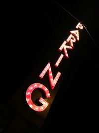 Low angle view of illuminated neon sign at night