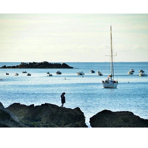 sea, horizon over water, water, transfer print, clear sky, men, scenics, tranquil scene, tranquility, nautical vessel, beach, beauty in nature, nature, shore, lifestyles, silhouette, leisure activity, sky