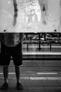 Low section of man standing on wet street