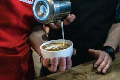 Midsection of person holding coffee cup