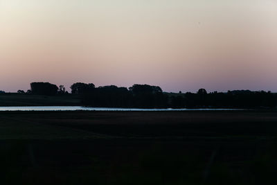 Scenic view of silhouette field against clear sky during sunset