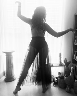 Rear view of woman standing at home