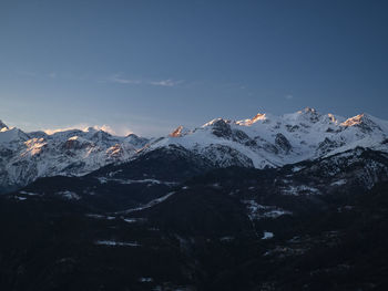 Scenic view of snowcapped mountains against clear blue sky