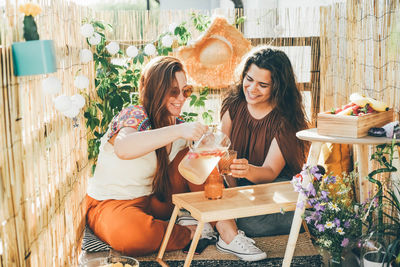 Smiling friends preparing drink