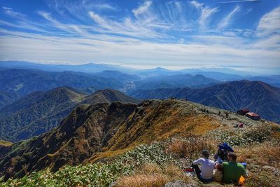 Rear view of people on mountains against sky