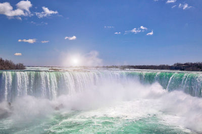 Scenic view of waterfall against sky