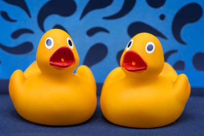 Close-up of yellow rubber ducks on blue textile