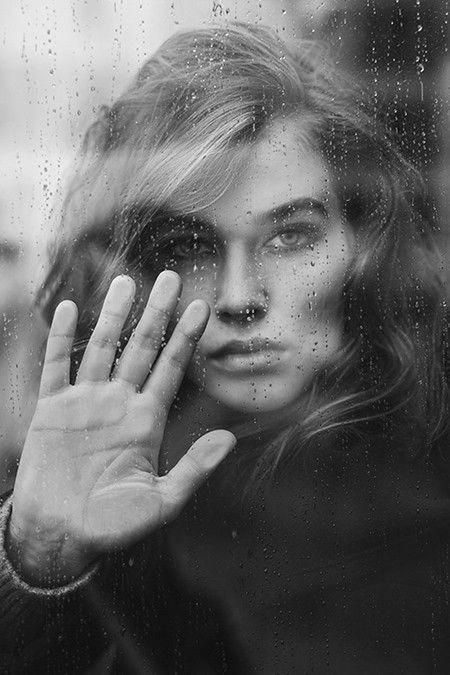 PORTRAIT OF A BEAUTIFUL YOUNG WOMAN WITH HANDS IN RAIN