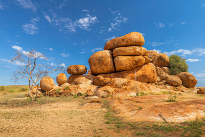 Rock formations on field against sky