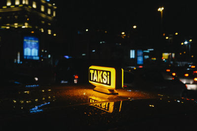 Road sign on street in city at night