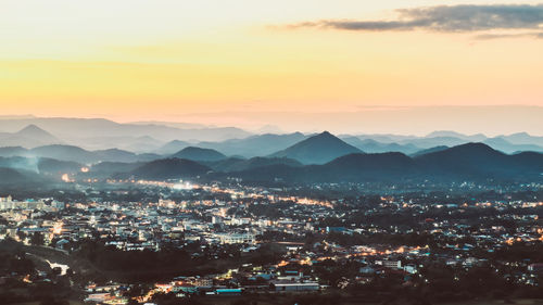 High angle view of illuminated cityscape against sky during sunset