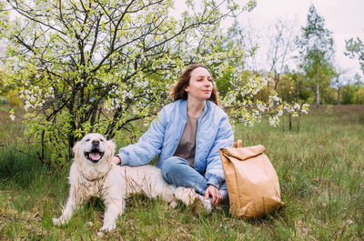 Portrait of woman with dog on field