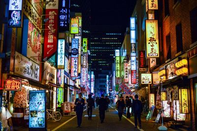 People walking on city street at night