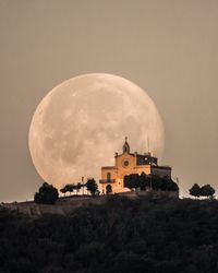 Full moon setting behind ermita de sant ramon