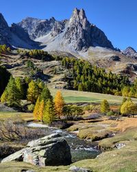 Scenic view of stream by mountains against sky