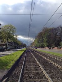 Railroad tracks against cloudy sky