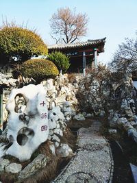 Sculpture on rock by building against sky